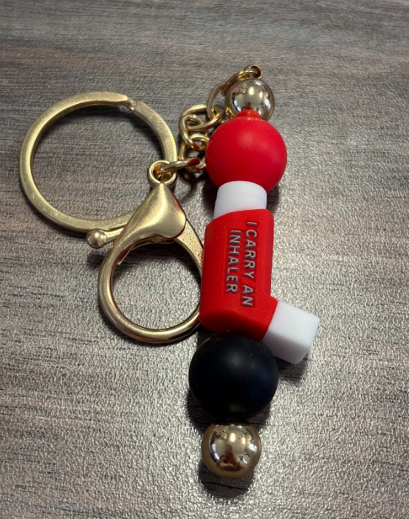 Red inhaler bag clip/keychain on gold.